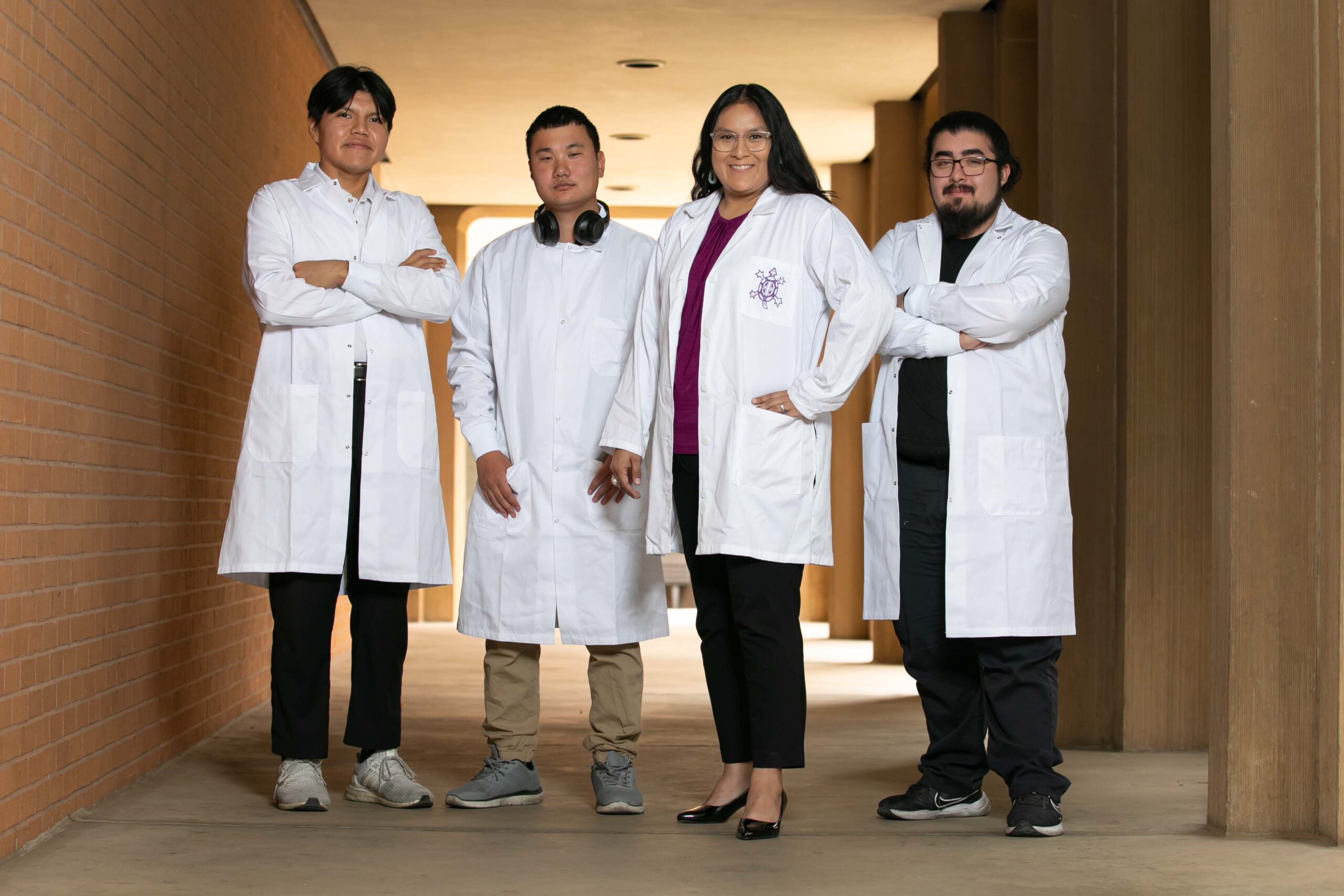 Dr. Krystal Tsosie, Geneticist and Bioethicist at Arizona State University in Tempe poses for a portrait with her graduate students - Kathleen Dreier Photography