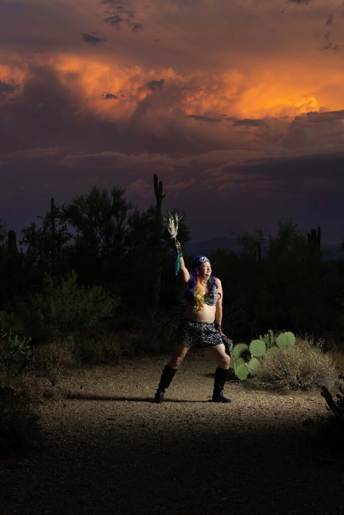 Dallas, wearing remaining layers of her zebra-themed clothes, strikes a powerful pose in the setting sun in desert off of McCain Loop and Gates Pass in Tucson AZ. This is one of the last images of her 77th birthday portrait series. Photo by Kathleen Dreier Photography.